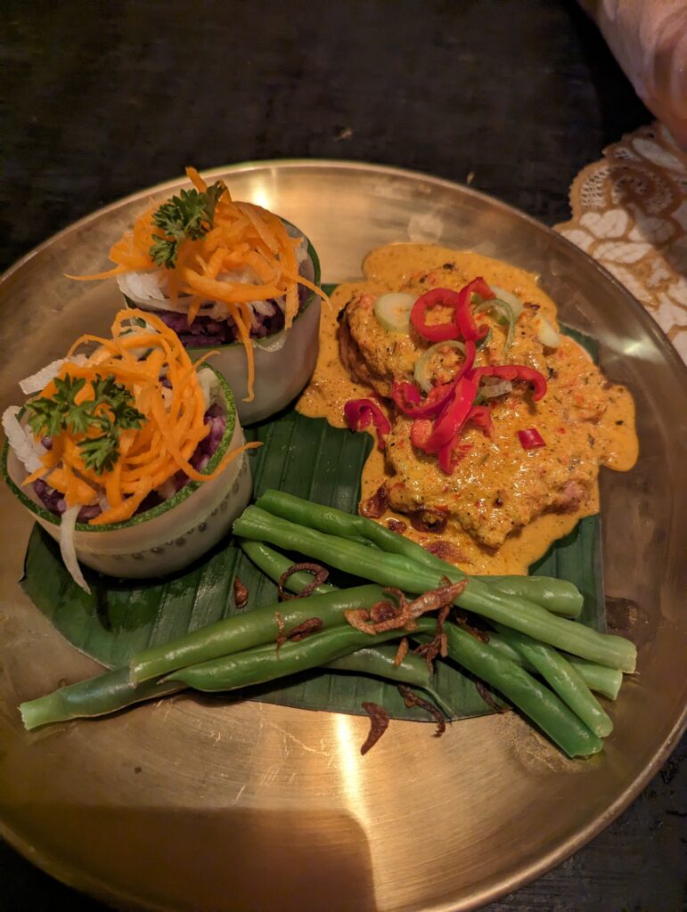 A plate of beans, chicken with a sauce, and another veggie side. Indonesian cuisine is truly so delicious!