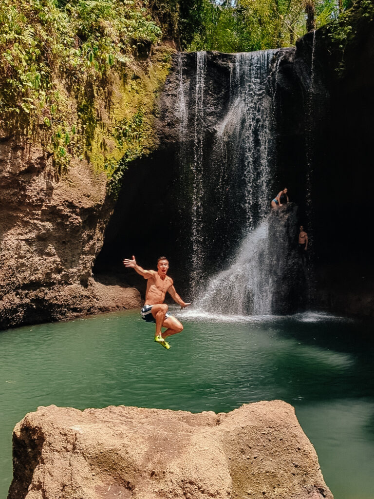 Derek jumping off a boulder