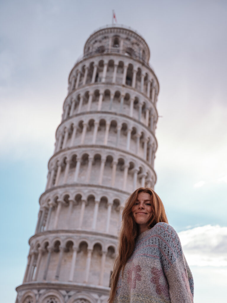 Lia standing below the Leaning Tower of Pisa