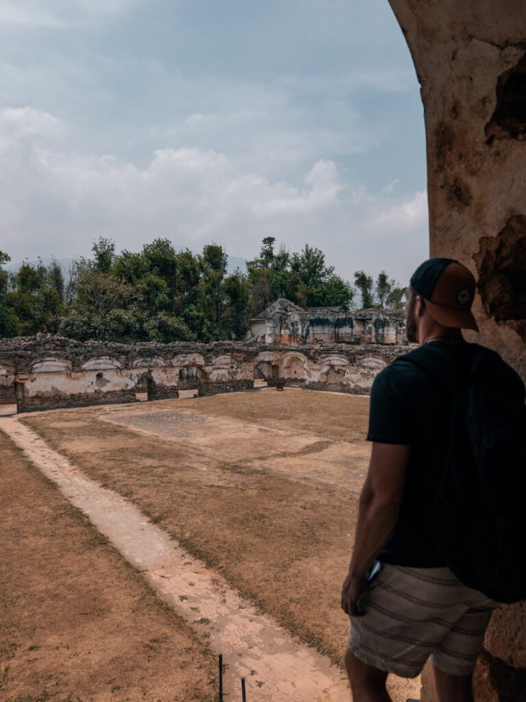 Matt looking out over a courtyard and ruins in the convent - Things to do in Antigua