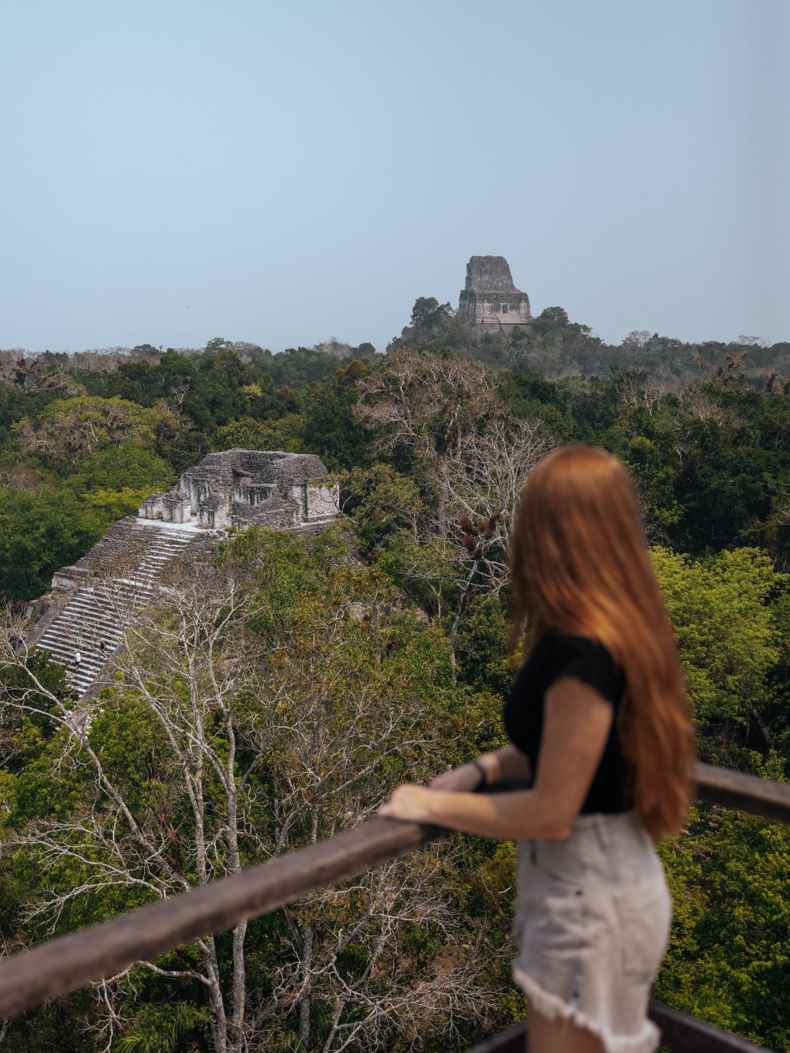 Lia looking out over the rainforest at the tops of other temples - Tikal National Park
