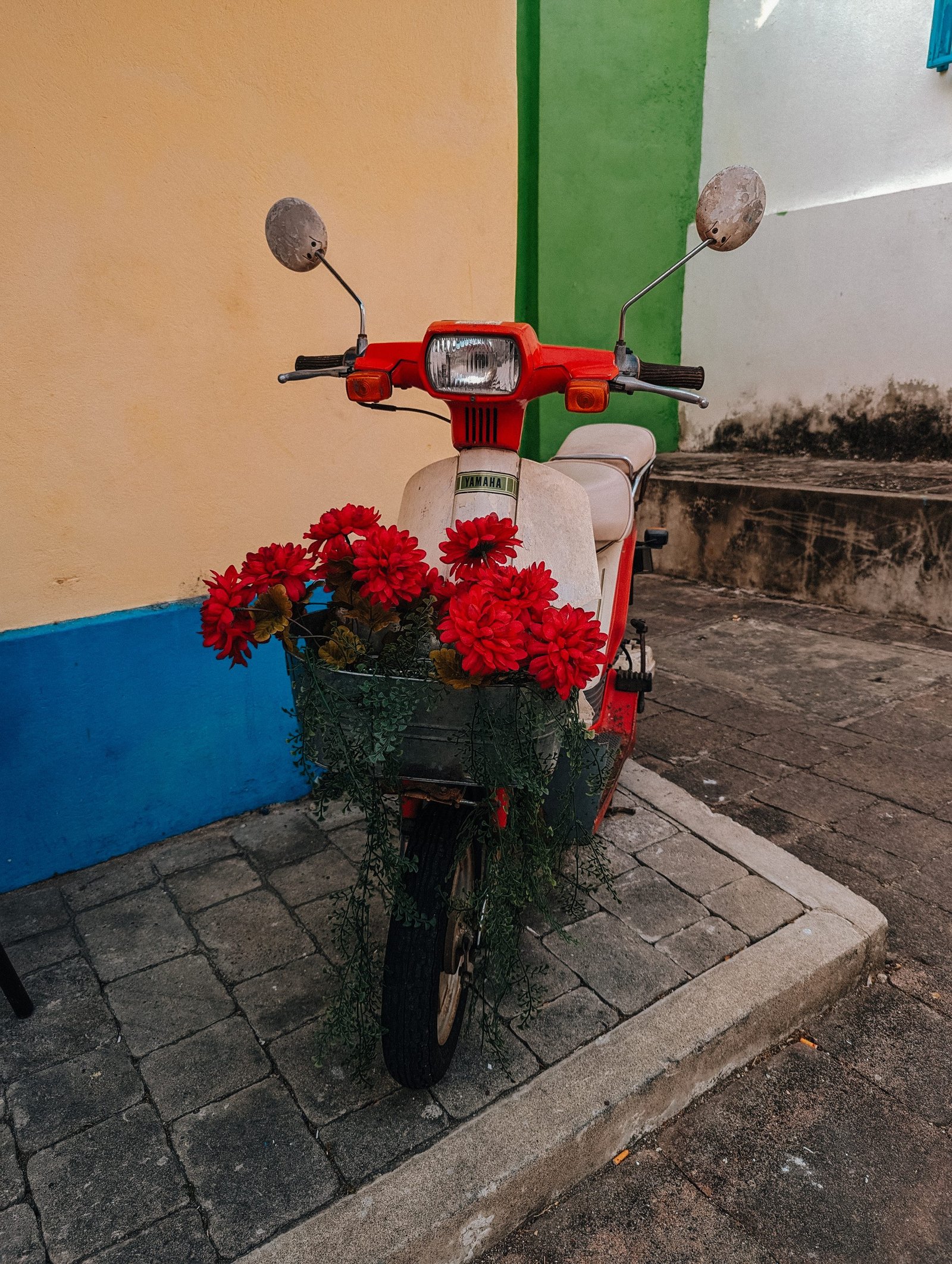 A moped with flowers in its basket